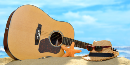 Guitar og hat på strand
