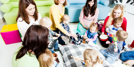 Fem mødre og syv små børn spiller musik