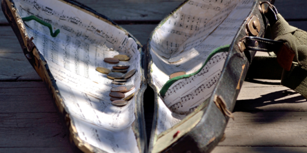 Åben violinkasse med penge i