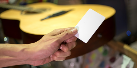 Guitar i baggrunden. Mand rækker en seddel frem.